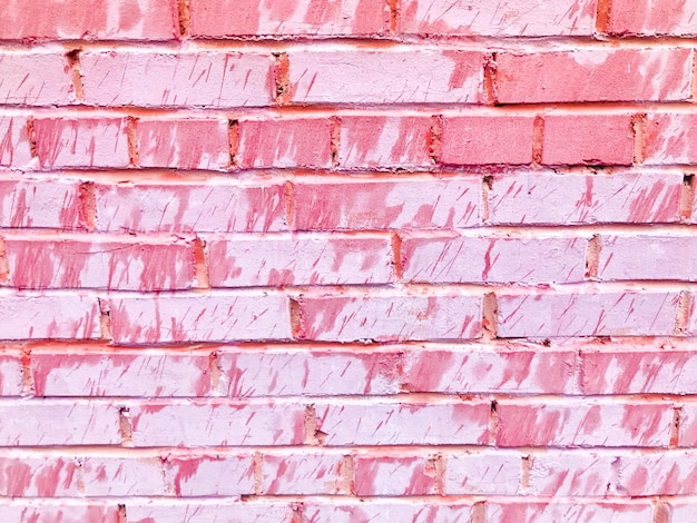 Texture of a beautiful unique unusual pink tender old cracked brick wall of rectangular bricks