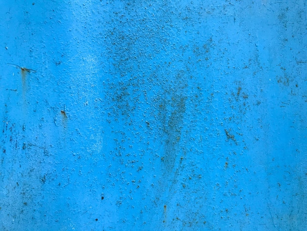 Texture in blue bright matte surface of unusual color metal sheet with paint smudges damage