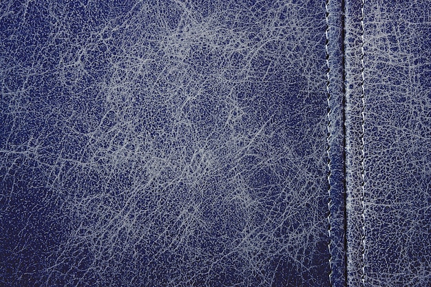 Texture blue leather with a vertical seam, closeup background