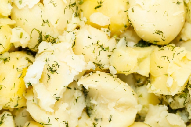 Texture of boiled broken potatoes with parsley as background