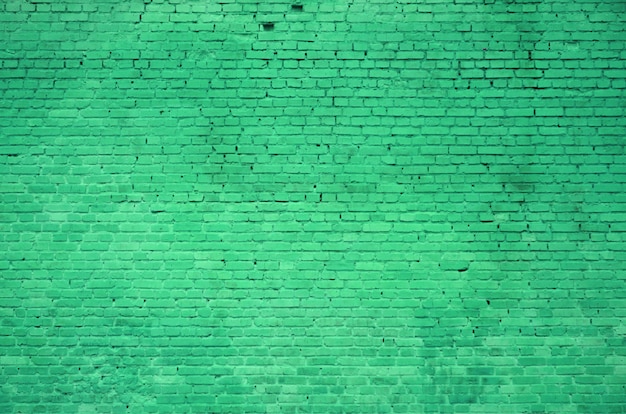 緑色で塗られたレンガの多くの行のレンガの壁の質感
