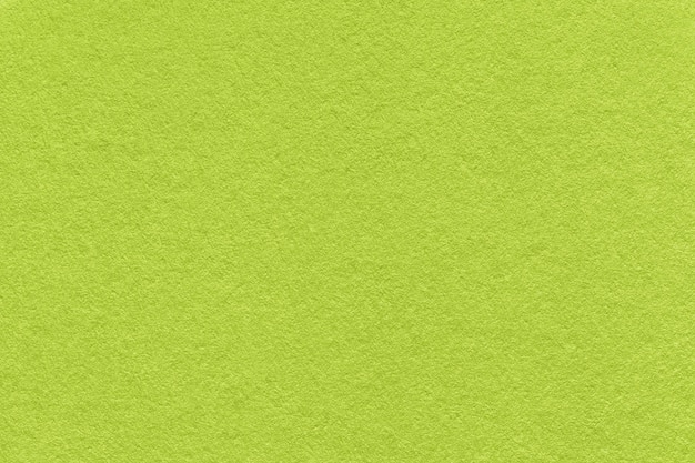 Texture of bright green and olive colors paper background macro Structure of dense lime craft cardboard Felt backdrop closeup