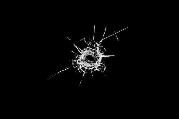 Texture of broken glass. Hole from a ball on a black background.