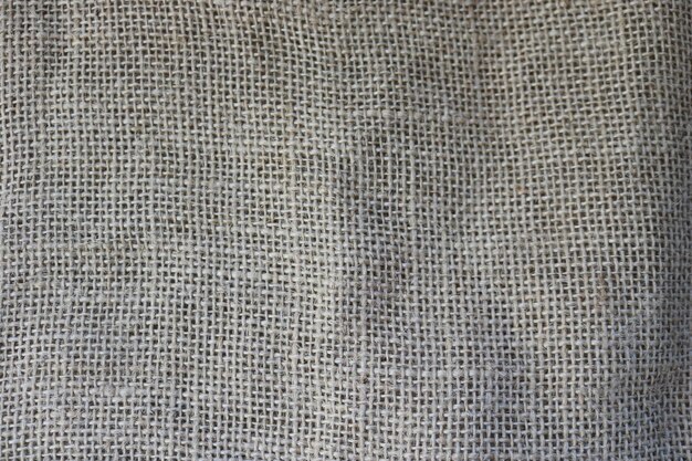 Texture of brown old canvas linen natural material with a coarse perpendicular interlacing