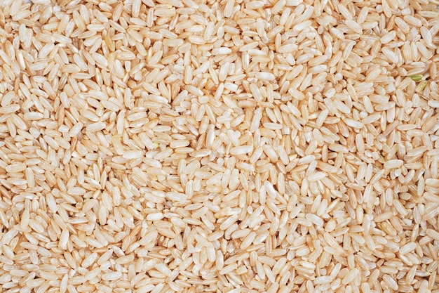 Texture Brown rice raw long grain. table close up.