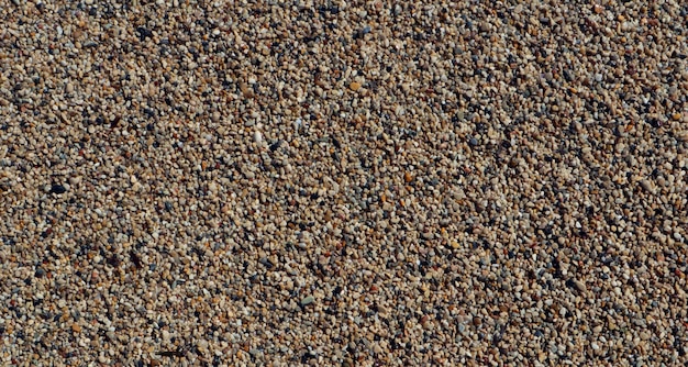 Texture of coarse sea sand close-up, small pebbles. For design, background, postcards, collages