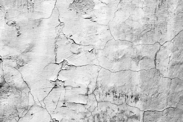 Foto trama di un muro di cemento con crepe e graffi che può essere utilizzato come sfondo
