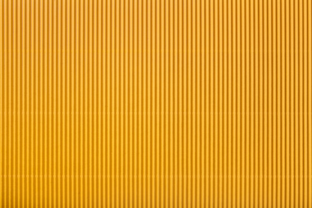 Photo texture of corrugated yellow paper, macro. striped pattern