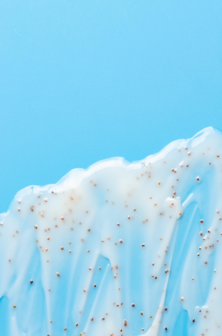 The texture of a cosmetic skin scrub with jojoba oil Blue background Copy space