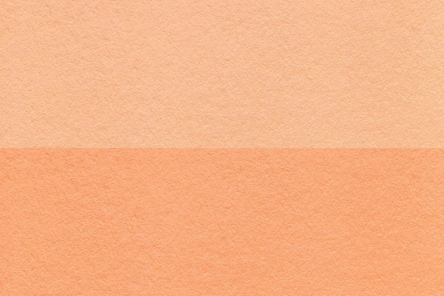 Texture of craft peach fuzz and coral paper background half two colors macro Vintage dense cardboard