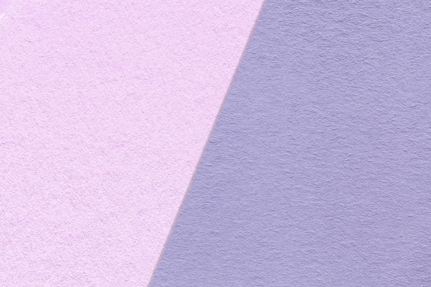 クラフトバイオレットとライラック紙の背景の半分の2色のマクロのテクスチャヴィンテージ紫の密な段ボールの構造