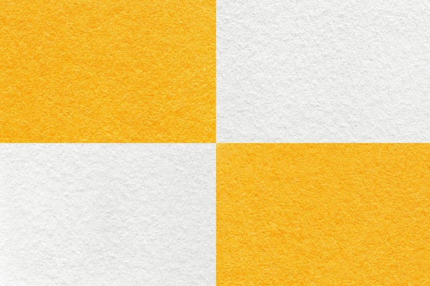 Texture of craft white and bright yellow paper background with cells pattern macro Kraft orange cardboard