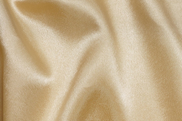 texture crumpled wrinkled golden or yellow fabric with glare closeup elegant background for your design material for sewing festive costumes and clothes