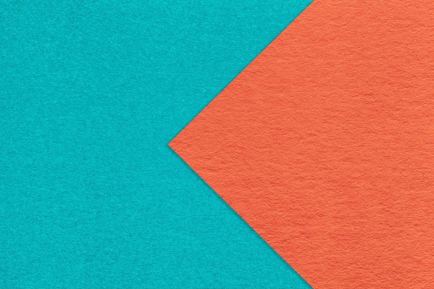 Texture of cyan and orange paper background half two colors with arrow macro Structure of cerulean cardboard