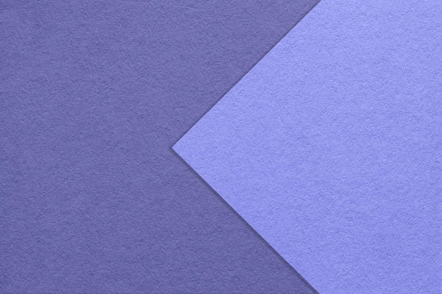 Texture of dark blue and violet paper background half two colors with arrow macro Structure of very peri cardboard