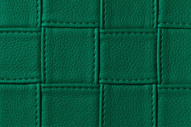 Texture of dark green leather background with square pattern and stitch.