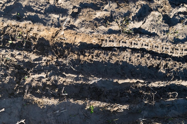 갈라진 틈과 흠집이 있는 마른 진흙이 있는 더럽고 나쁜 비포장 도로의 질감 오프로드