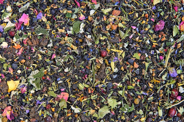 Texture of dry black tea mixed with herbs leaves and dried berries