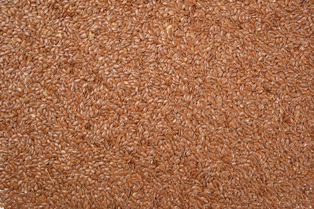 Texture of dry brown flax seeds, top view, full frame