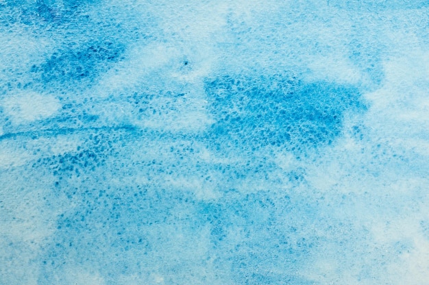 白い紙の上の青い水彩画の汚れからのテクスチャ