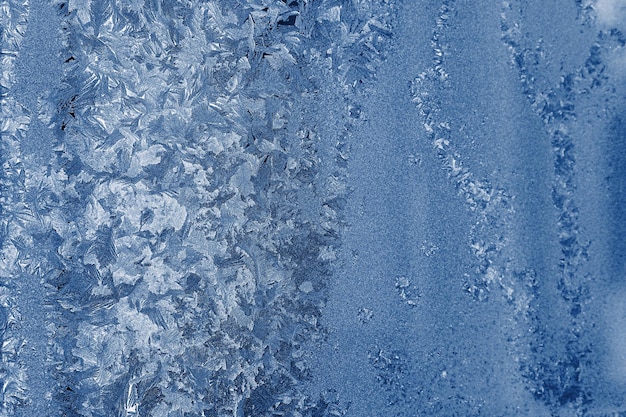 Texture of frosty glass with an abstract pattern from hoarfrost of silvery blue color