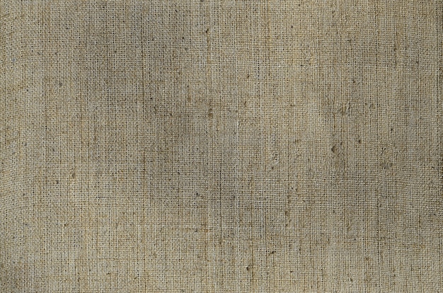 Texture of a gray canvas made of old and coarse burlap. Top view