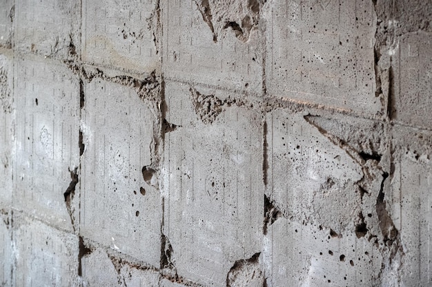 해체된 직면 타일의 흔적이 있는 회색 콘크리트 벽의 질감