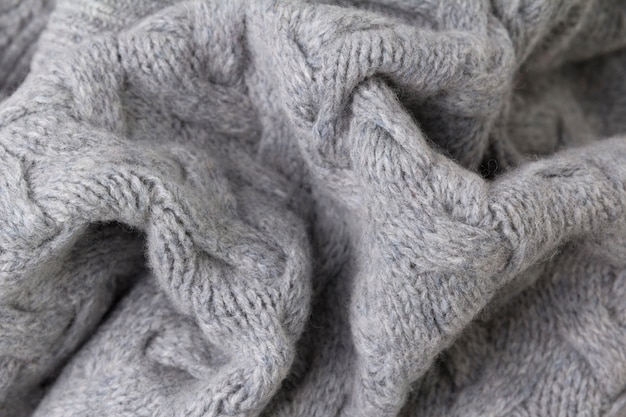 Texture of gray knitted fabric close up. Wool knitwear.