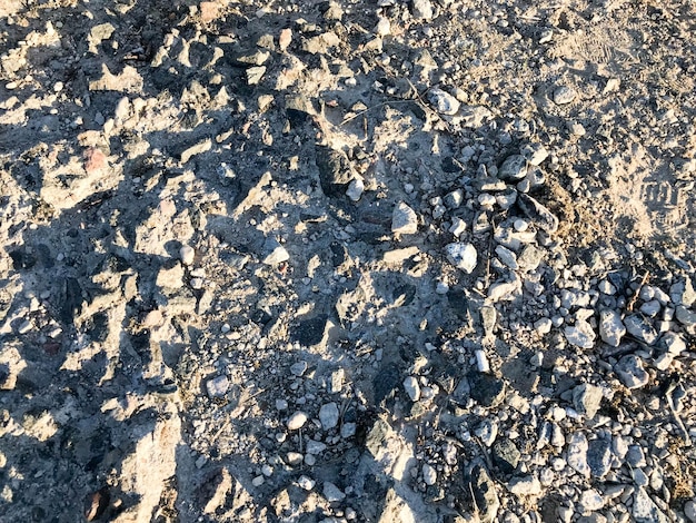 The texture of a gray stone broken crumbling cement stone floor walls of old reinforced concrete