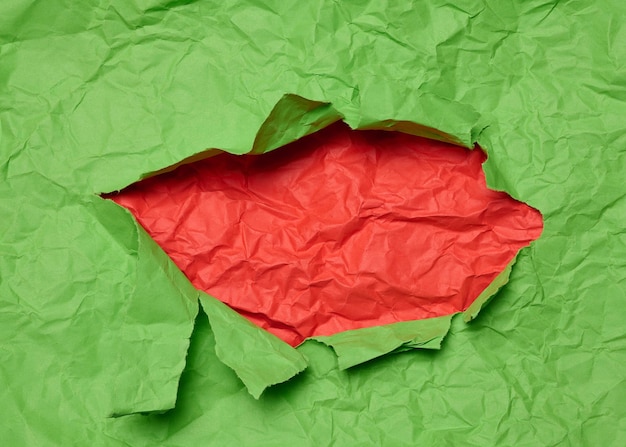 Текстура зеленой бумаги с рваной дырой и красным шаблоном фона для дизайнера