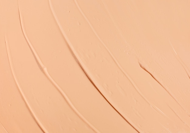 Texture of light beige makeup liquid foundation as a background