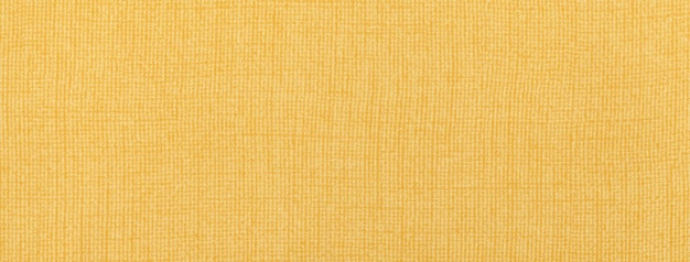 Texture of light yellow color background from textile material with wicker pattern macro Vintage golden fabric cloth