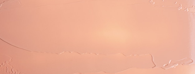 Foto la trama del fondotinta liquido beige sfocatura sfondo crema di make-up. banner largo.