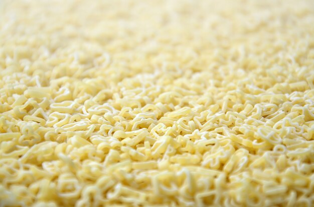 Texture of a lot of curly raw yellow pasta