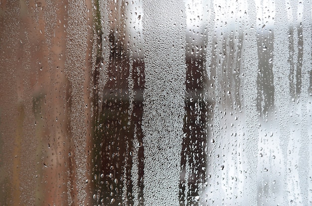 Photo the texture of a misted glass with a lot of drops and condensation flows.