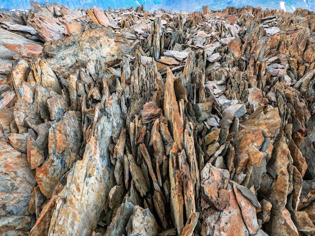 산의 질감입니다. 위험한 날카로운 바위. 날카로운 돌 배경입니다. 어두운 회색 색상의 분할 돌의 추상 질감. 큰 금이 뾰족한 돌 근접 촬영입니다.