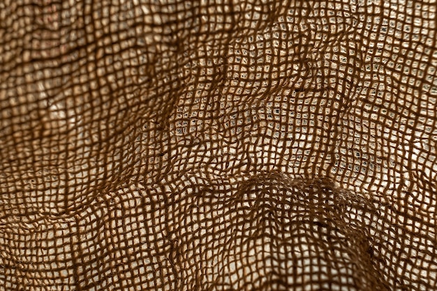 Texture of natural burlap material close-up, with natural folds and draperies
