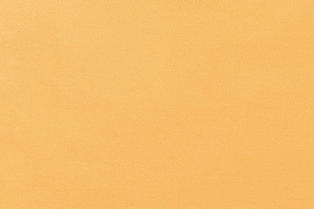 Texture of natural orange color twill fabric closeup the background for your mockup