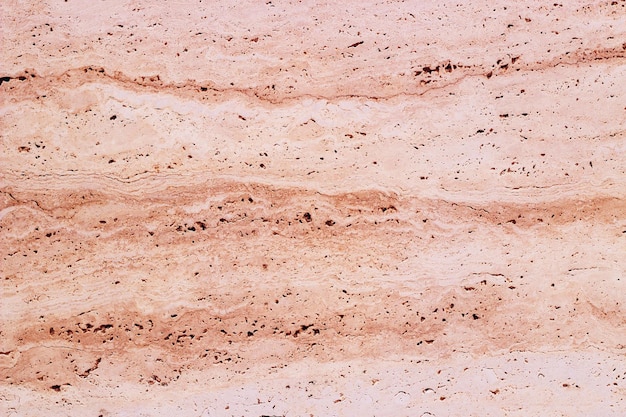 The texture of natural stone of a pink shade is similar to marble.