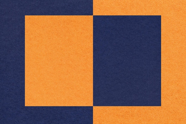 Texture of navy blue and orange paper background with geometric shape and pattern macro Structure of dense kraft cardboard Felt backdrop closeup