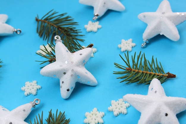 Фото Текстура белых звезд, снежинок и еловых веток рождественская открытка на нежно-голубом цвете красивые елочные игрушки