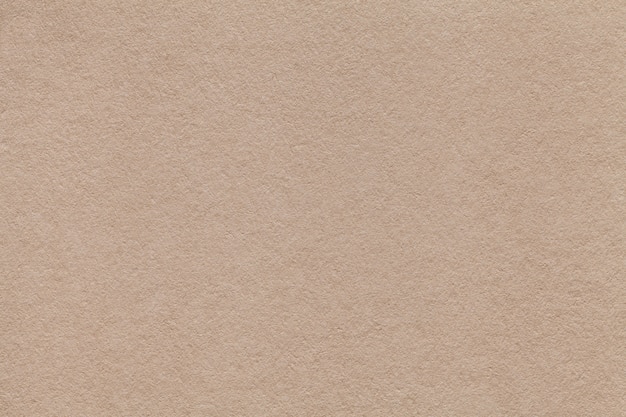 Texture of old beige paper closeup. Structure of a dense cardboard sand color. The background.