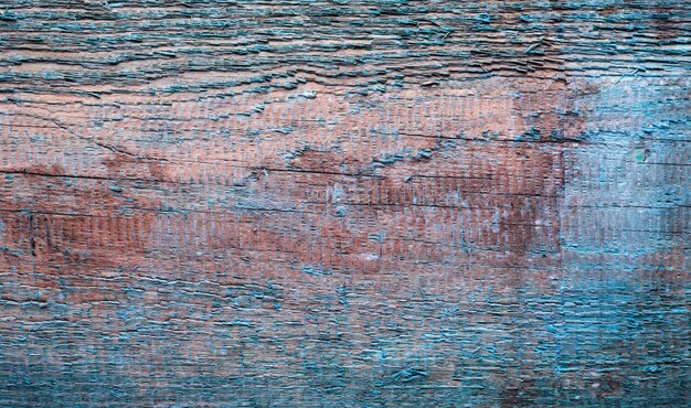 The texture of old board with peeling blue paint.