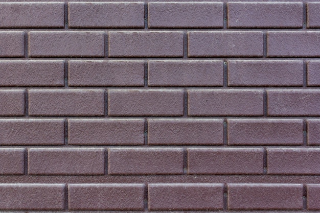 Texture of old brick wall with worn brown paint