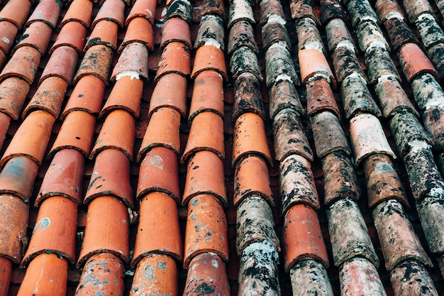 The texture of the old brown shingles on the roof of the building