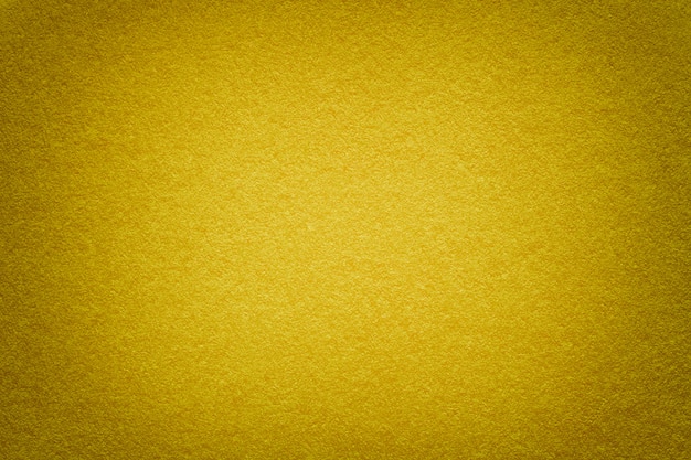 Texture of old golden paper background, closeup. Structure of dense cardboard.