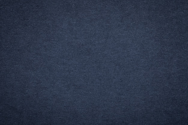 Текстура старой бумаги сини военно-морского флота, крупного плана. Структура плотного темного джинсового картона
