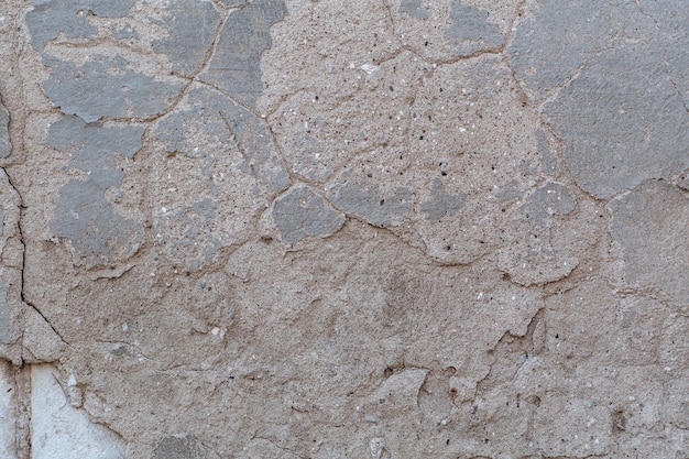 The texture of the old painted wall with which the plaster is peeling building destruction