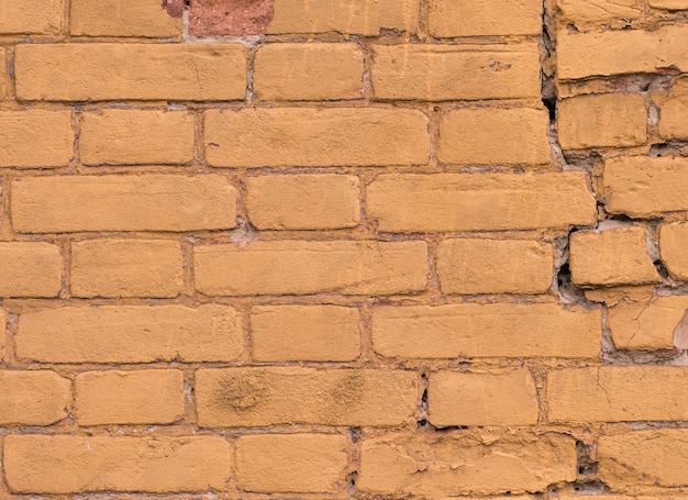 Texture of old painted yellow brick of color