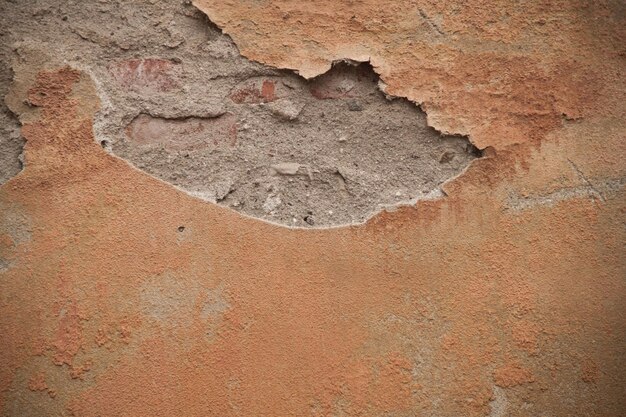 Texture of an old ragged wall Background of old bricks and cracks in plaster Yellow and brown tones